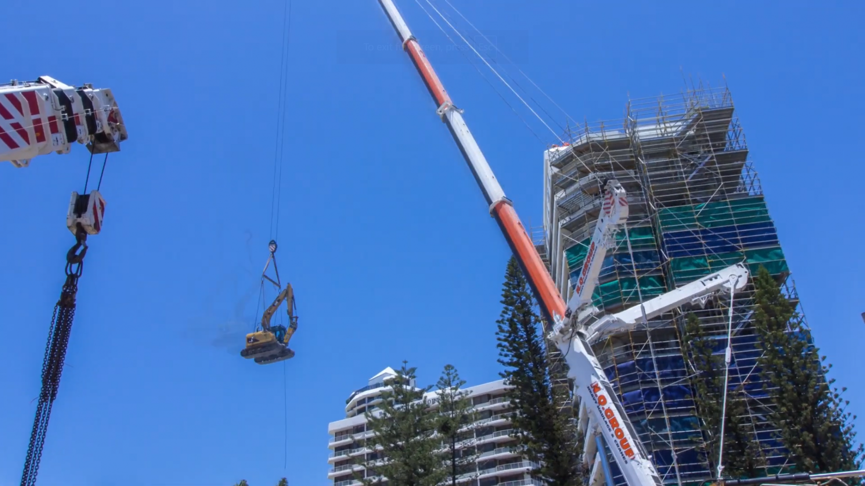 Excavator being lifted by crane